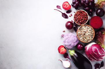 Purple vegetables, fruits on grey background. Violet eggplant, beets, cauliflower, purple beans,...