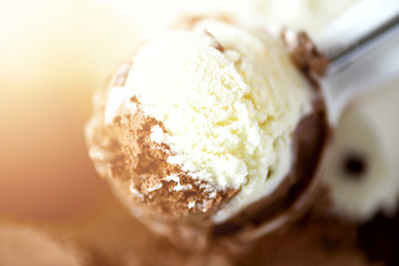 Scooped vanilla and chocolate ice cream background. Summer food concept, copy space, top view. Sweet yogurt dessert or brown ice-cream texture.