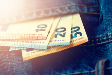 Obraz premium Euro banknotes in jeans pocket. Success, wealth and poverty, poorness concept. Euro currency background with copy space.