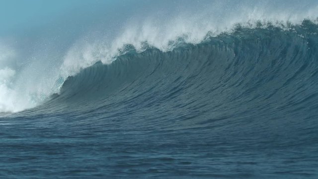 SLOW MOTION, CLOSE UP: Cool huge barrel wave coming from the ocean surges towards the beach. Amazing shot of powerful Cloudbreak wave in Fiji crashing and spraying countless water droplets everywhere.