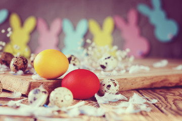 Easter composition of Easter colorful eggs in the basket and with bunny garland. Toned image.