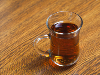 Tea in glass Cup on wooden table background.