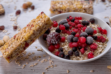 Oatmeal, nuts, woody fruit on wood background, ingredients, healthy food