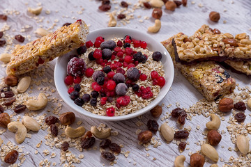 Oatmeal, nuts, woody fruit on wood background, ingredients, healthy food