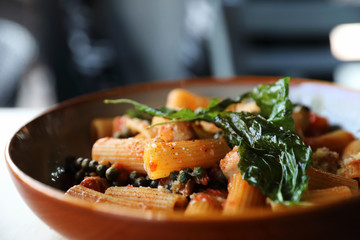 Pasta with sausage in tomato sauce on wood background , italian food