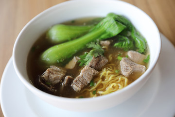 Chinese noodles with pork on wood background
