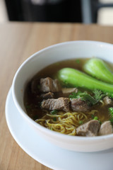 Chinese noodles with pork on wood background