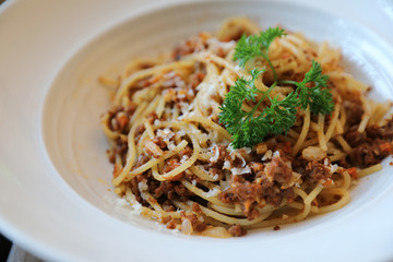 spaghetti Bolognese with minced beef and tomato sauce garnished with parmesan cheese and basil , Italian food