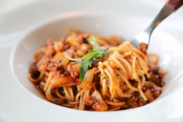 spaghetti Bolognese with minced beef and tomato sauce garnished with parmesan cheese and basil , Italian food