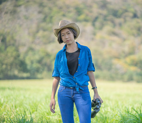 Woman wear hat and hold binocular in grass field