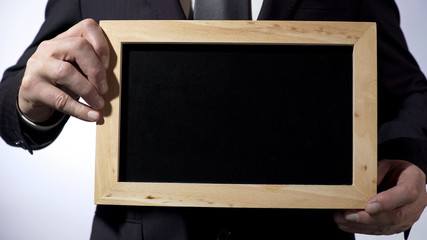 Blackboard template with empty space for your text, businessman holding sign