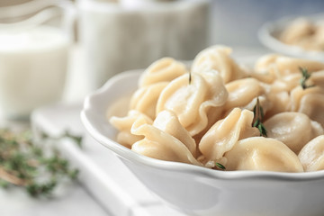 Bowl with tasty meat dumplings on table, closeup