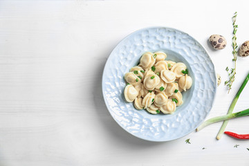 Plate with tasty meat dumplings on wooden background
