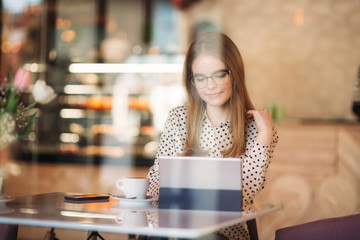 beautiful blond lady use different gadgets and drinking coffee in cafe