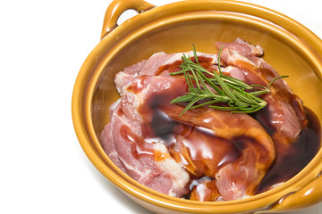 Raw pork meat steaks with spices in bowl.