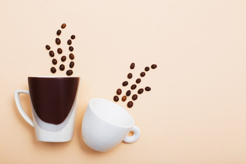 coffee beans and a two cups on a light background