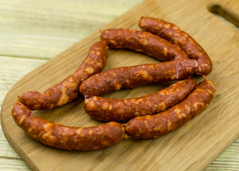 Smoked natural sausages   on a wooden surface.