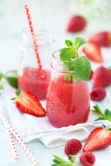 Healthy antioxidant red smoothie with apple juice, fresh strawberries, raspberries and mint