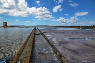 Trapani, Italy, Sicily August 20 2015. The fabulous salt pans of Trapani, with its characteristic pink salt. Coloration due to microalgae that survive despite the extreme salinity of the water.