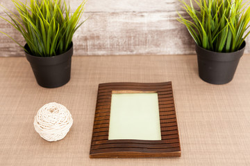 Photo frame on the table next to pots of grass