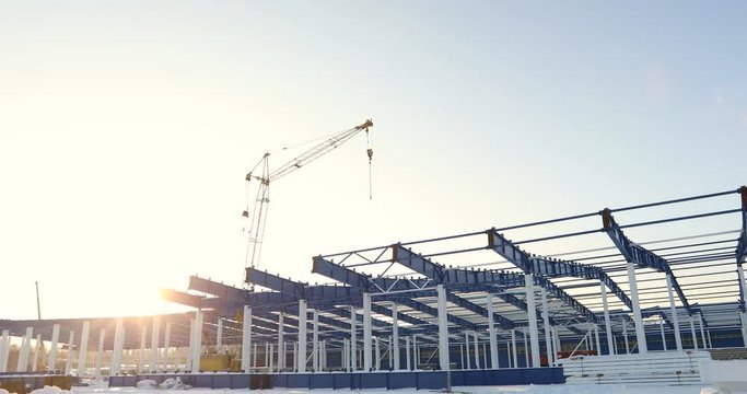 Modern storehouse construction site, the structural steel structure of a new commercial building against a clear blue sky in the background, Construction of a modern factory or warehouse