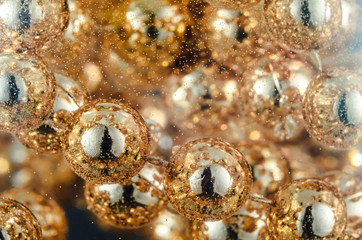 Gold beads in water with bubbles, macro, photo, background for design or Wallpaper.