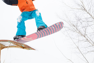 Picture of bottom of sportive man skiing on snowboard with springboard