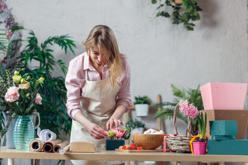 Image of blonde florist making composition of flowers