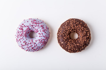 Glazed berry and chocolate donuts with sweet sprinkles on white background