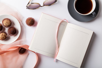 Variety of chocolate truffles with a cup of black coffee on white background