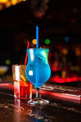 Two different cocktail on the bar. Colorful blue lagoon and orange cocktail. © Bohdan