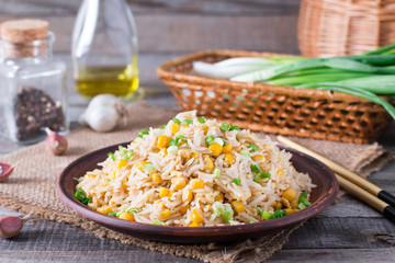Asian fried rice with eggs and corn on the plate on wooden background