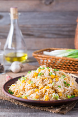 Asian fried rice with eggs and corn on the plate on wooden background