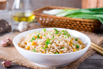 Asian fried rice with eggs and corn on the plate on wooden background