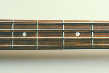 Frets on bass guitar. Close up. Vintage old retro bass in studio. Warm soft style