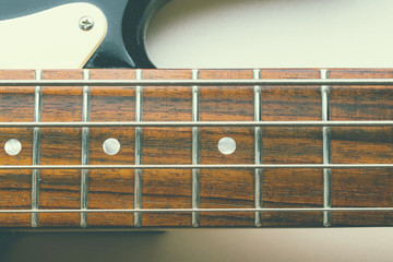 Frets on bass guitar. Close up. Vintage old retro bass in studio. Warm soft style