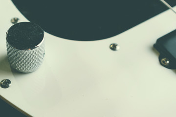 Button switch on bass guitar. Close up. Vintage old retro bass in studio. Warm soft style