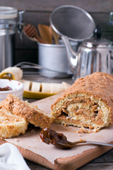 Homemade sweet biscuit roll with cream on wooden background