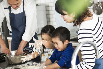 ピザの生地が手にくっついた。女の子と男の子が奮闘中。お手伝い。キッチン。