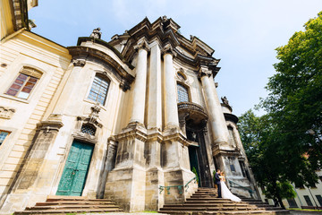Obraz premium beautiful building with incredible architecture and newlyweds standing on the stairs