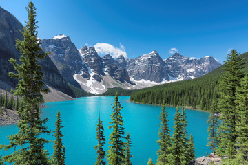 Beautiful turquoise waters of the Moraine Lake with snow-covered peaks above it in Rocky Mountains, Banff National Park, Canada.