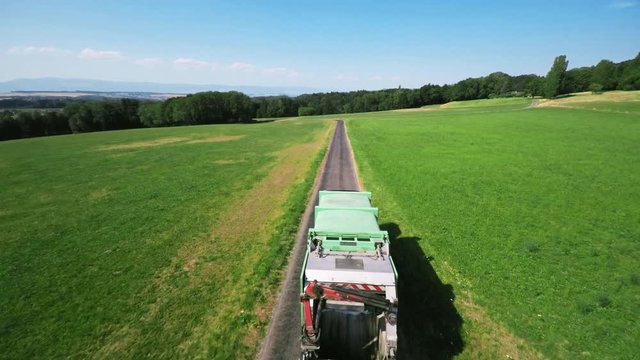 Aerial shot of a waste truck / lorry. Scenic aerial shot in the countryside
