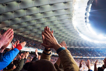 Football- soccer fans support their team and celebrate goal in full stadium with open air with nice sky.-blur picture.