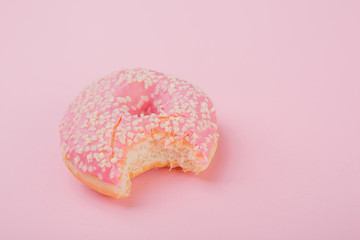 donut pink icing  bitten one side pink background