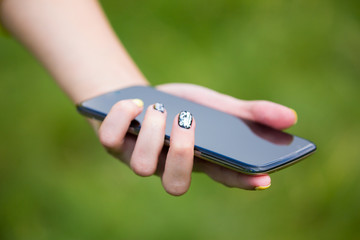 A girl with a phone in her hand outdoors