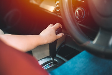 closeup women driver hand shifting gears inside car vintage color tone
