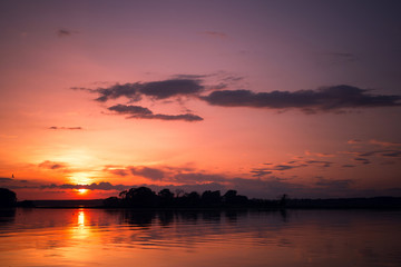 Fototapeta na wymiar Beautiful blazing sunset at lake