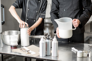 Chefs mixing ingredients for ice cream production in the professional kitchen. Close-up view wuth no face