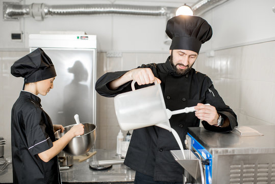 Chef pouring basis into the ice cream freezer machine in the small manufacturing