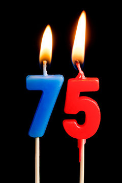 Burning candles in the form of 75 seventy five figures (numbers, dates) for cake isolated on black background. The concept of celebrating a birthday, anniversary, important date, holiday